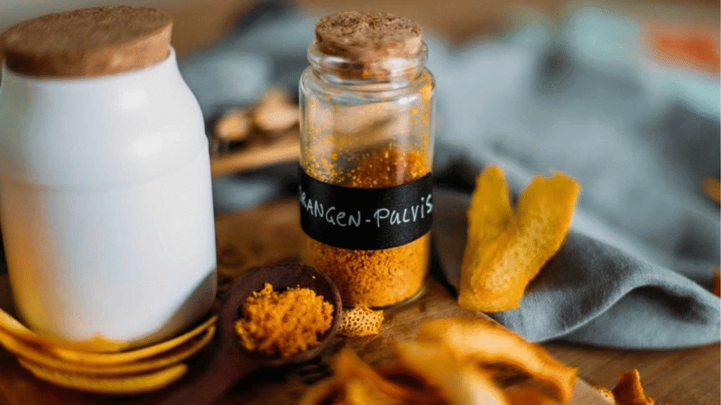 Selbstgemachtes Orangenpulver aus getrockneten Orangenschalen in einem Glas