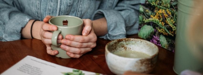 Hände halten eine Tasse Kräutertee
