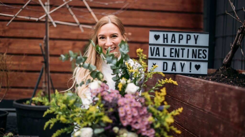 Patricia mit Blumen und Schild zum Valentinstag