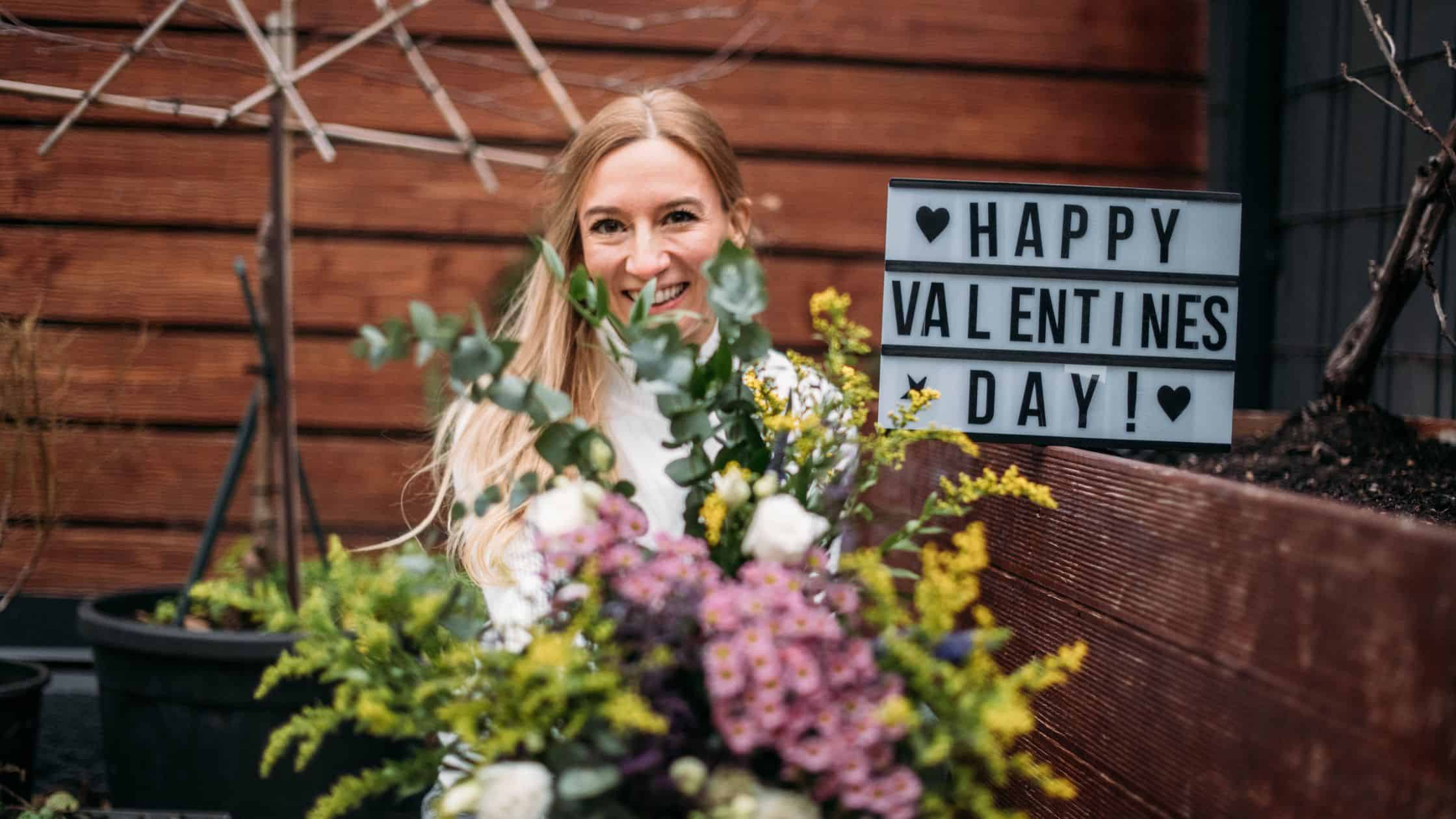 Patricia mit Blumen und Schild zum Valentinstag