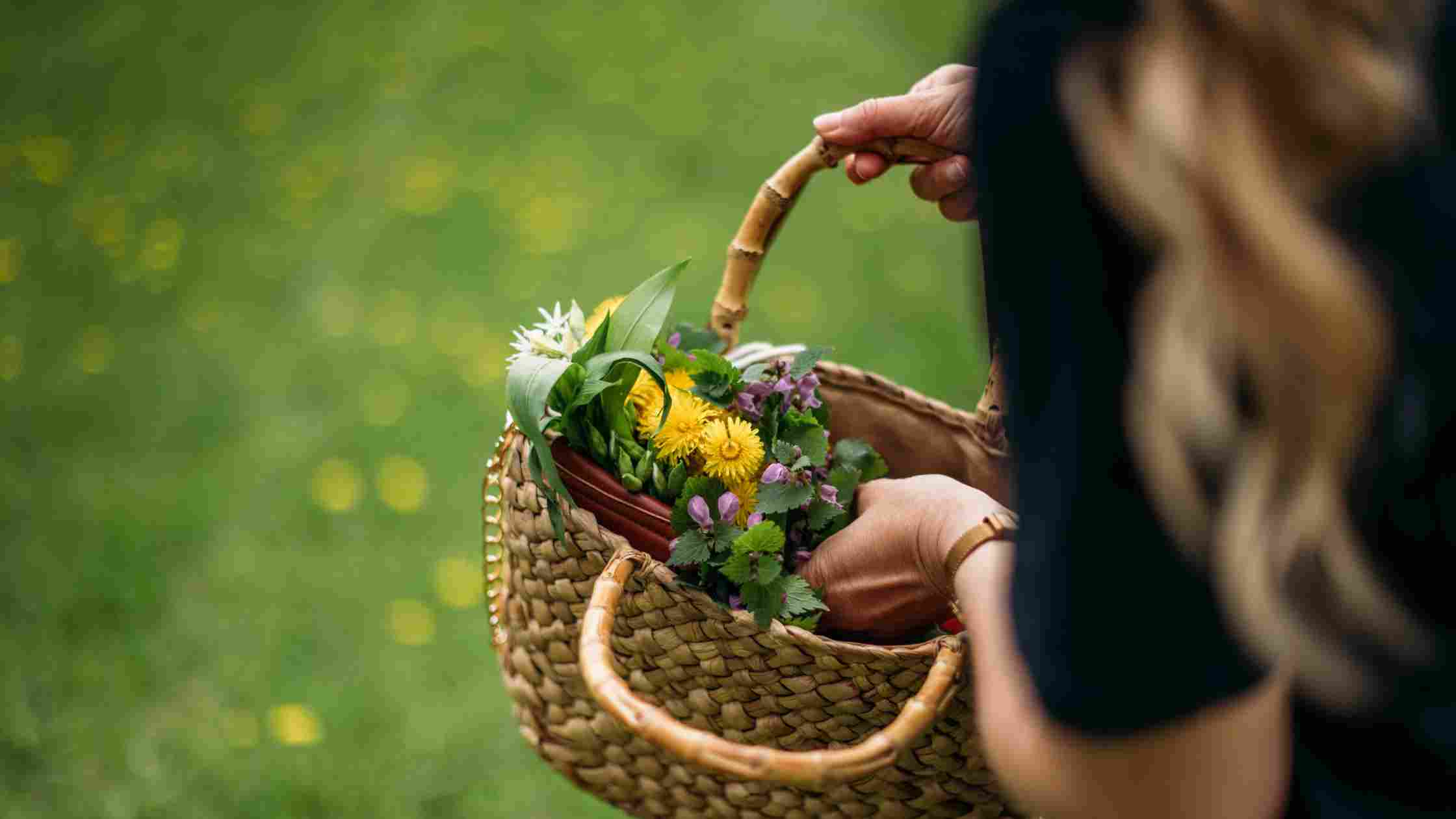 Löwenzahn und Blüten in Frühlingsstrauß in einem Korb